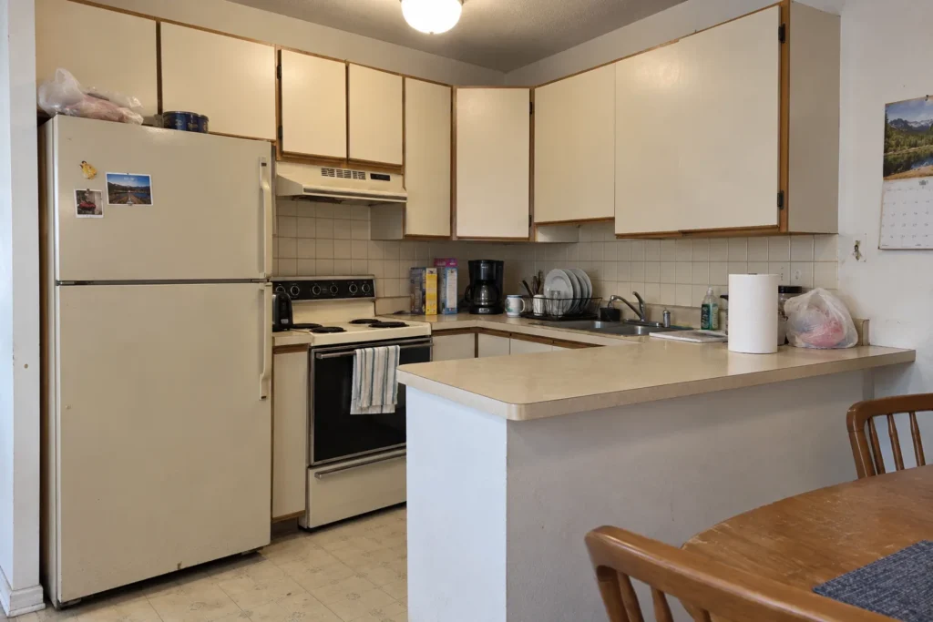 Original 1990s U-shaped apartment kitchen before renovation in Denver, Colorado