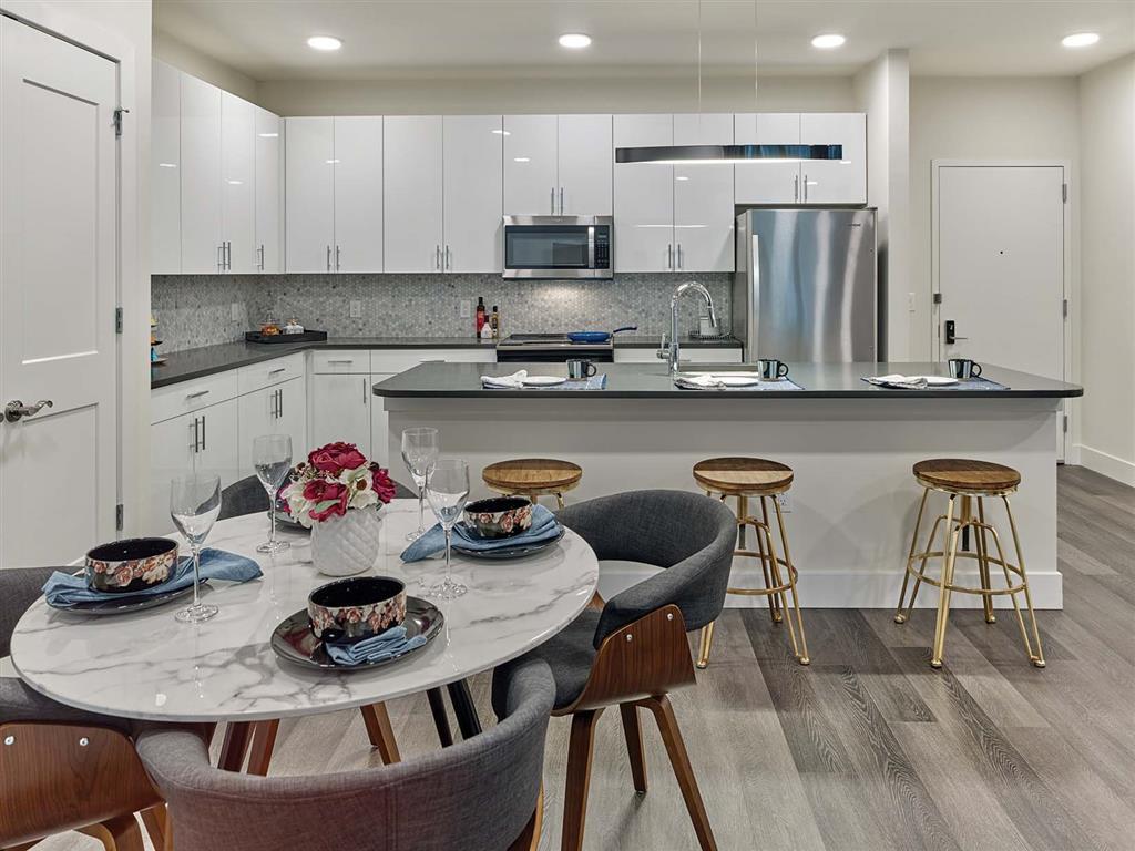 Glossy white slab kitchen with charcoal quartz peninsula in Union, New Jersey